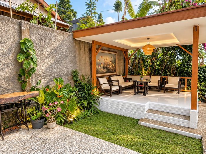 Gazebo di taman dengan sofa dan rumput hijau